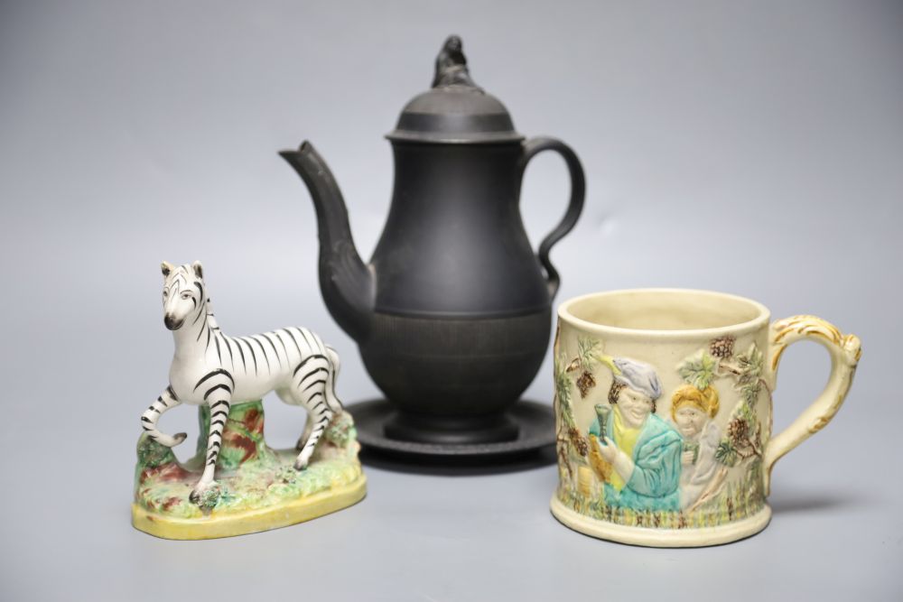 A 19th century Staffordshire pottery model of a zebra, a Victorian relief-moulded frog mug, a black basalt coffee pot with cover on sta